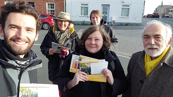 5 Lib Dems including Will Aczel hold up canvass cards by the corner of Well Street